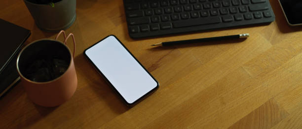 istock Mock up smartphone on rustic workspace with digital tablet, mug and supplies 1256262129