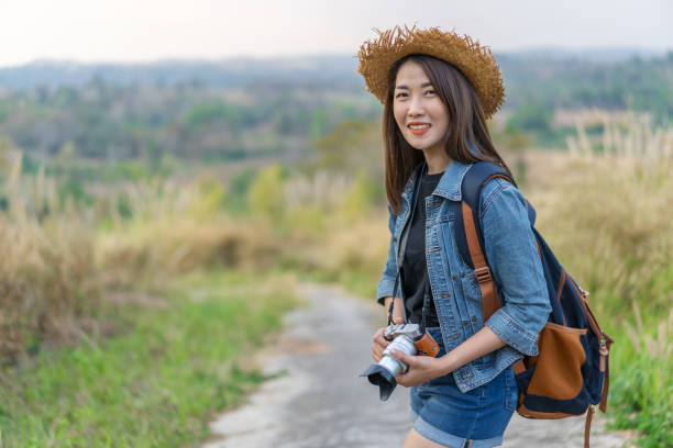 istock female tourist with backpack and camera in countryside 1256262458