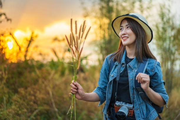 istock female tourist with backpack and camera in countryside with sunset 1256262465