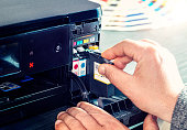 Technician changing Cartridge Inks in a Computer Printer