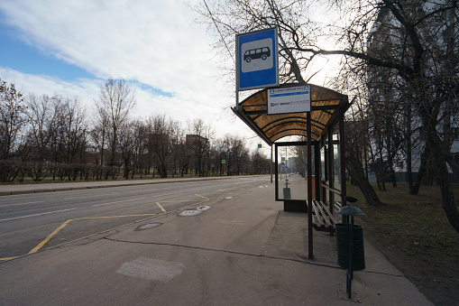 Moscow, Russia - April 5, 2020: Bus stop in the spring day. Translation of the inscription in russian - 6th Novoostankinsky proezd, subway Timiryazevskaya. No people. Coronavirus pandemic time.