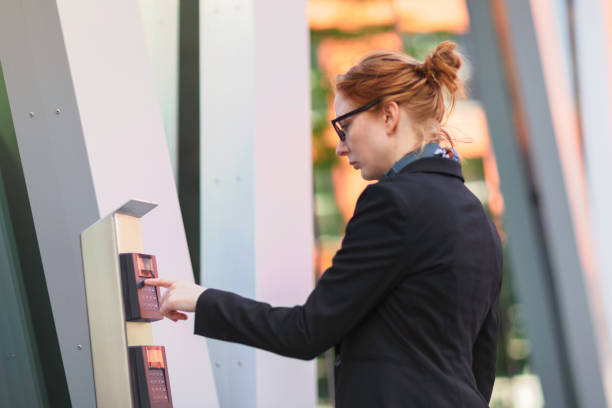 istock Woman entering a security code at an office building entrance 1256266999
