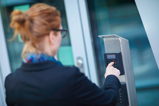istock Woman using a security keypad at a building entrance 1256267073