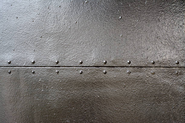 istock Black sheets of metal connected by a seam with rivets 1256268489