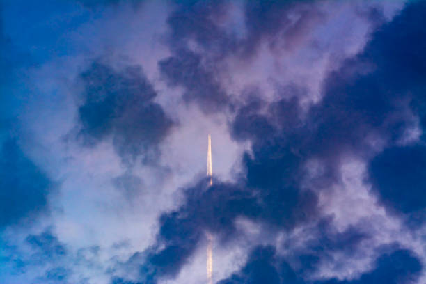 istock An airplane with a long jet trail flies above the clouds 1256268547