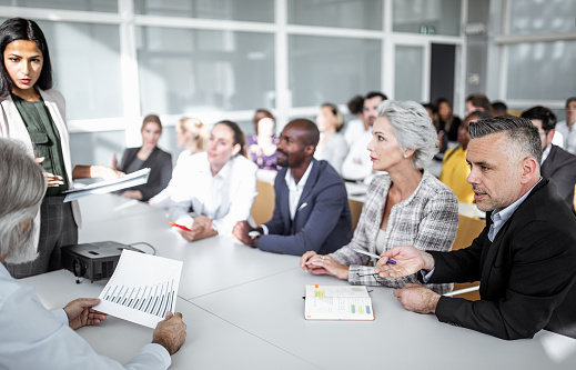 Senior Male Investor Sitting In Crowd And Using Laptop Computer At International Technology Conference. Caucasian Man Listening To Keynote Presentation About Innovative Startup Company Service.