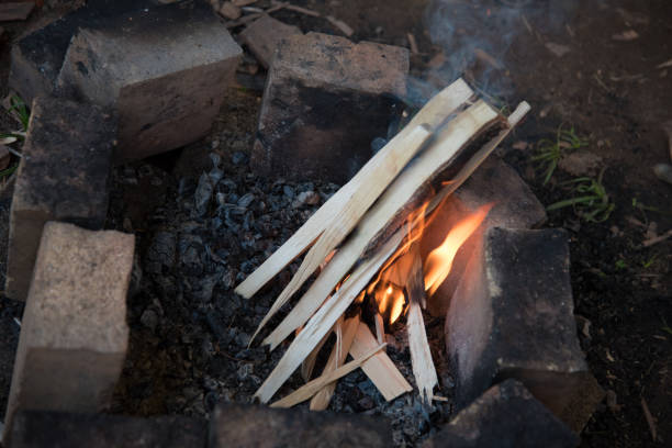 istock A place for a fire, fenced with bricks. The process of starting a fire. Small wood and chips begin to burn. 1256270457