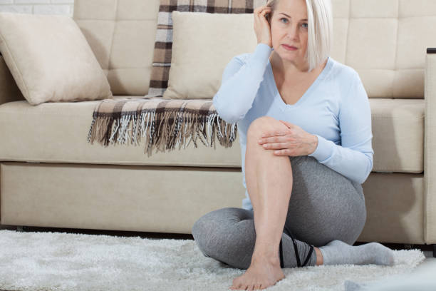 Middle-aged woman suffering from pain in leg at home, closeup. Physical injury concept. Middle-aged woman suffering from pain in leg at home, closeup. Physical injury concept. Ankle pain, painful point. painfully stock pictures, royalty-free photos & images