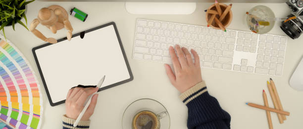 istock Female designer working with mock up tablet, computer and designer supplies on white desk 1256274908
