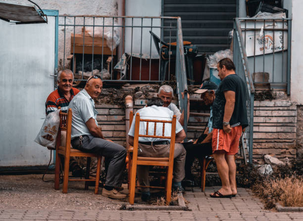 Group of elderly Italian men sitting in the main square in San Gimignano, Italy discussing important issues.
