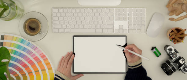 istock Female designer working with mock up tablet, computer, camera and supplies on white desk 1256275158