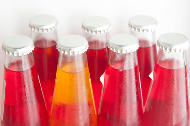 istock Be different concept: a bottle yellow soft drink between many red bottles 1256275312