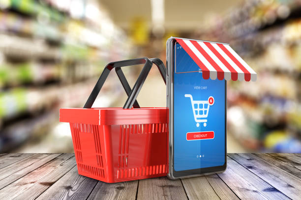 Mobile phone with an online store application on the screen stylized on the store facade and shopping basket on supermarket interior background as symbols of online internet shopping - 3d illustration stock photo