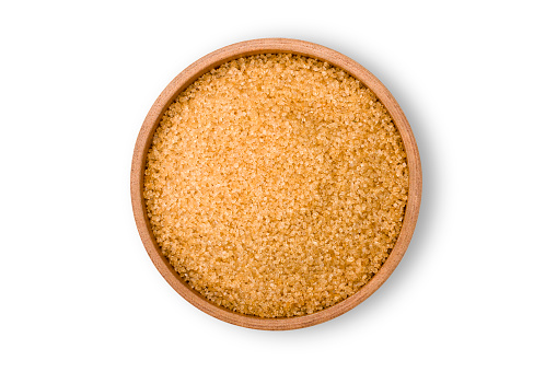 Closeup brown sugar in wooden bowl isolated on white background with clipping path. Unhealthy diet ,awareness and stop diabetes concept.