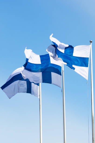 istock Three finnish national flags on the wind against the blue sky 1256280299