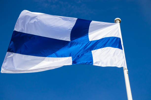 istock Finnish national flag on the wind against the blue sky 1256280330