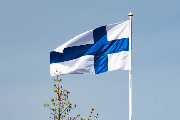 istock Finnish national flag on the wind against the blue sky 1256280343