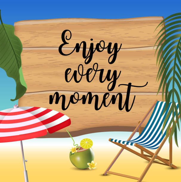 istock Enjoy every moment typography inscription with parasol, chaise launge and coconut coctail on beach background. Realistic sun flare. 1256280489