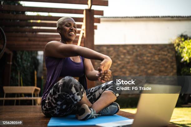 Woman Doing A Virtual Exercise Class Stretching Her Arms Stock Photo - Download Image Now