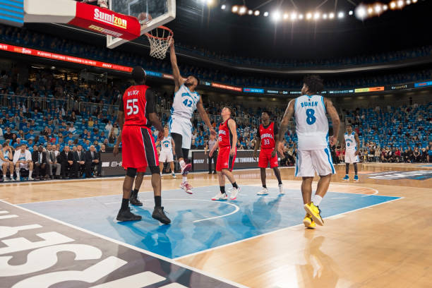 istock Basketball player slam dunking ball 1256280794
