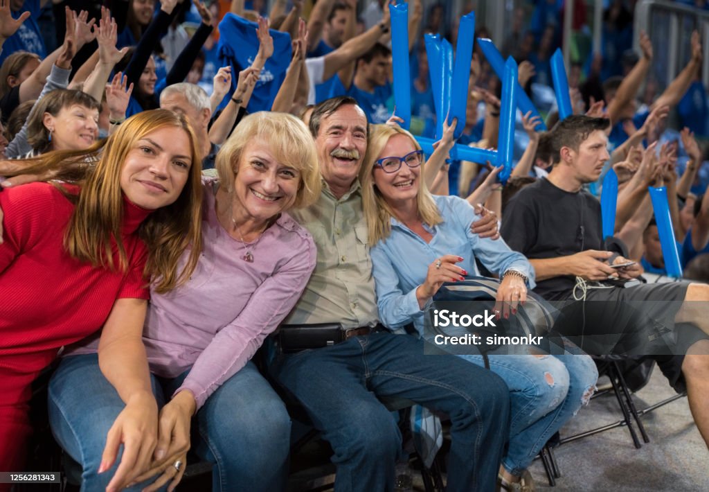 Smiling family sitting in stadium Portrait of smiling family sitting in stadium during basketball match. Match - Sport Stock Photo