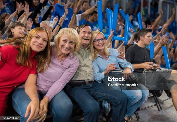 Smiling Family Sitting In Stadium Stock Photo - Download Image Now - Match - Sport, Stadium, Fan - Enthusiast