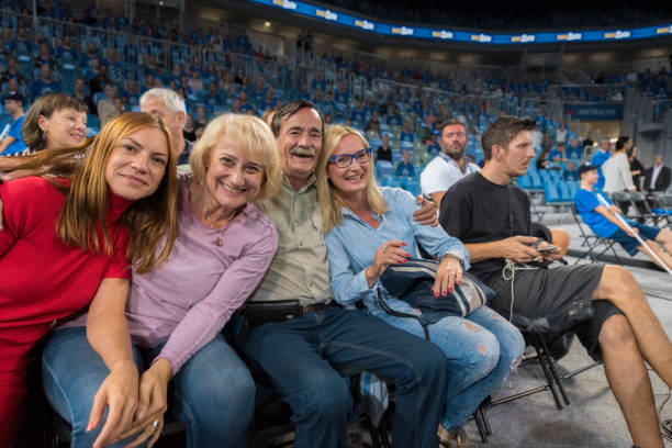 Smiling family sitting in stadium Portrait of smiling family sitting in stadium during basketball match. basketball sport photos stock pictures, royalty-free photos & images