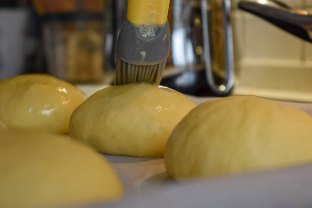 istock Raw burger buns being coated with yolk 1256281433