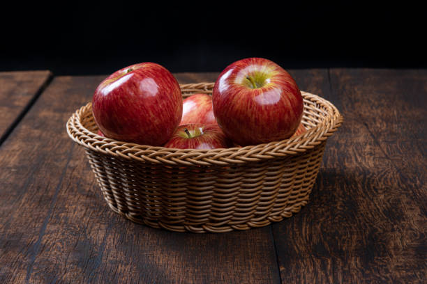 istock Apple in a basket on a rustic wooden surface with a black background. selective focus. 1256281437