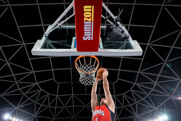 istock Basketball player slam dunking ball 1256281648