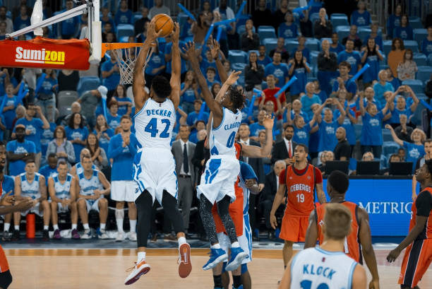 istock Basketball player slam dunking ball 1256281728