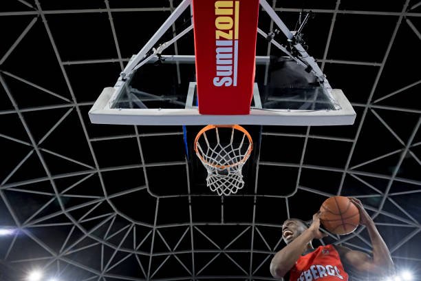 istock Basketball player slam dunking ball 1256281817
