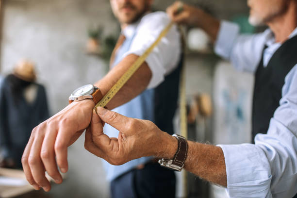 istock Professional tailor taking arm measurements for a suit 1256283037