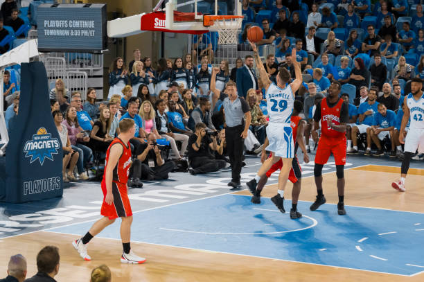 istock Basketball player slam dunking ball 1256283380