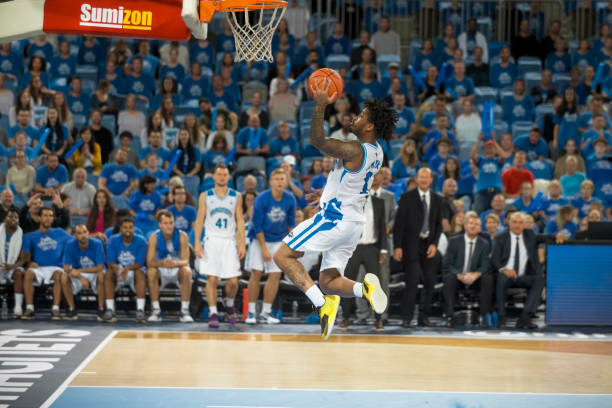 istock Basketball player slam dunking ball 1256283383