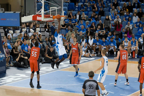 istock Basketball player slam dunking ball 1256283391