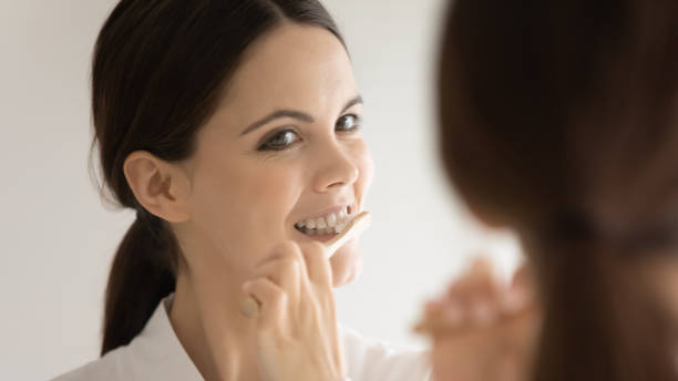 istock Close up mirror reflection woman with healthy smile cleansing teeth 1256287049