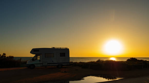 istock Camper vehicle on beach at sunrise 1256290182