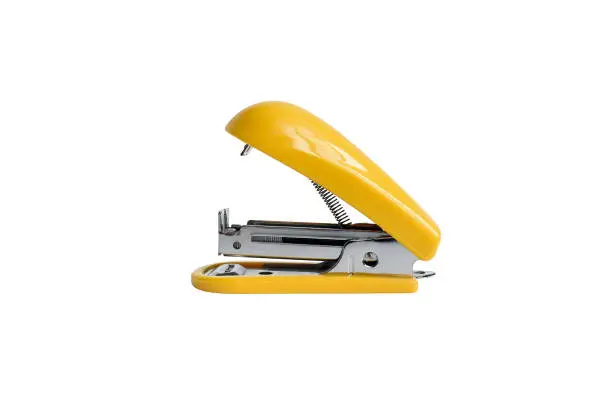 Office paper stapler in yellow on a white background. Isolate closeup.