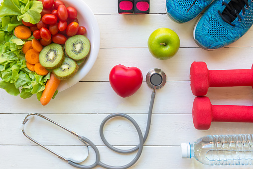 Health Care.  Fresh vegetable salad and green apple with medical stethoscope for diet and weight loss for healthy care and protect virus,  white wooden background.
