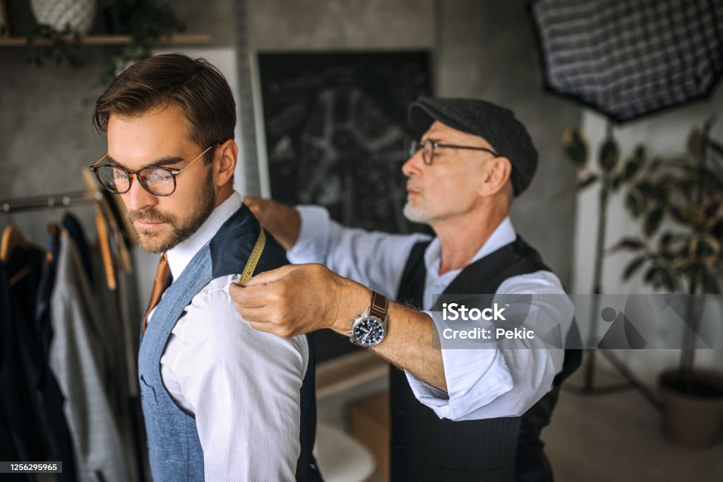 Professional tailor taking back measurements for a suit Professional clothing designers working process Customized Stock Photo