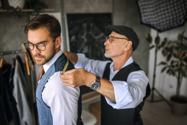 Professional tailor taking back measurements for a suit Professional clothing designers working process tailor stock pictures, royalty-free photos & images