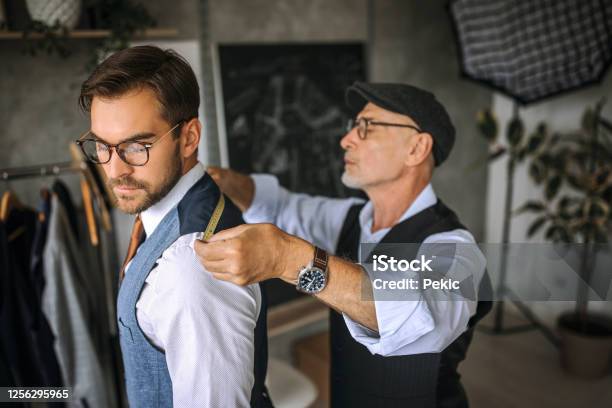Professional Tailor Taking Back Measurements For A Suit Stock Photo - Download Image Now