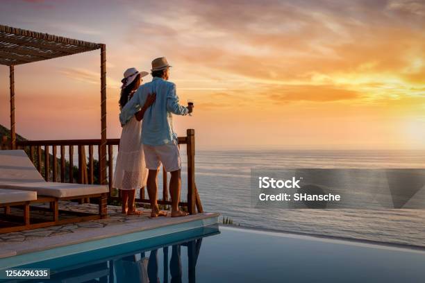 A Romantic Couple On Summer Vacation Enjos The Sunset Over The Mediterranean Sea By The Pool Stock Photo - Download Image Now