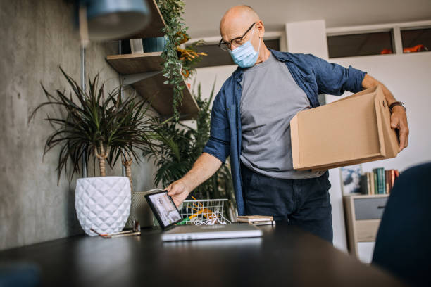istock Senior man packing stuff in his home office 1256297873