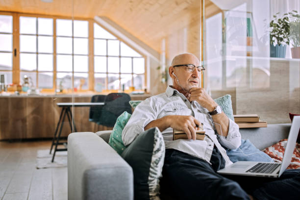 istock Elderly man on a sofa having a video call 1256298184