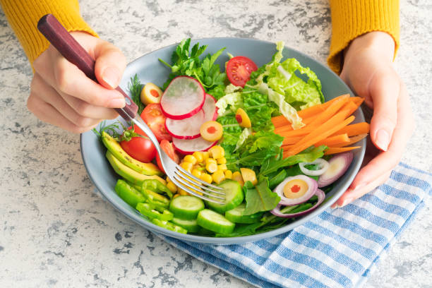 istock Woman eating vegan salad 1256298794