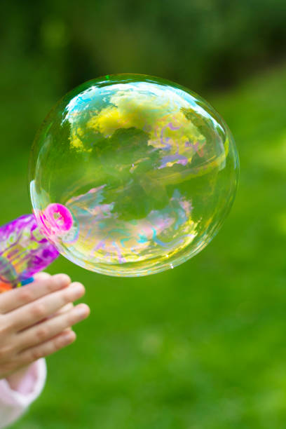 istock Making soap bubble outdoor. Summer fun activity for kids. Abstract education, play games concept. 1256299475