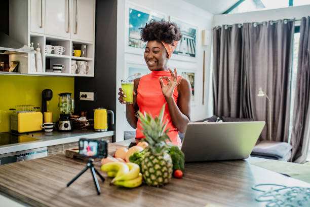 istock Female vlogger in the kitchen preparing healthy meal 1256299497