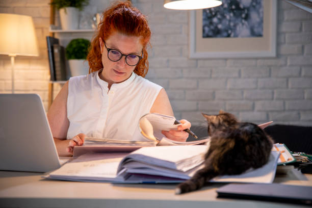 istock Woman working late alone with a cat 1256300831